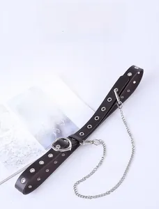 Detail of black punk leather belt with silver eyelets, heart ring and detachable chain