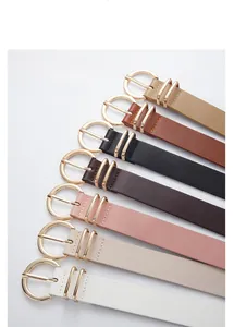 Detail of seven matte PU leather belts with golden round buckles in various colors