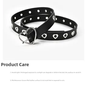 Détail d'une ceinture en cuir noir avec boucle cœur argentée et œillets en forme de cœur
