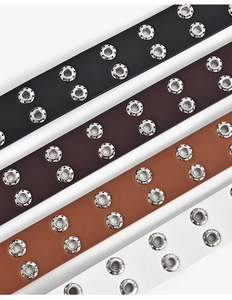 Vue détaillée de ceintures à œillets double rangée en noir, marron, fauve et blanc