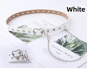 Détail de la ceinture punk blanche en similicuir avec œillets cœur et chaîne argentée