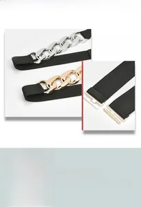 Detail of elastic waist belt featuring large gold and silver decorative metal links