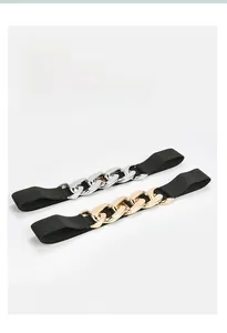 Detail of black elastic waist belts with chunky gold and silver interlocking chain links