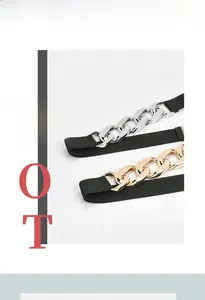 Close-up of black elastic belts with chunky gold and silver chain link buckles
