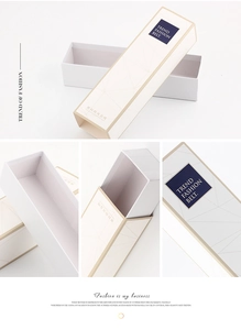 Dettagli macro della confezione regalo per cintura color crema con bordo oro e cassetto