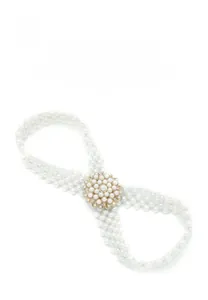 Detail van elastische riem met witte parels en een elegante gouden bloemvormige gesp