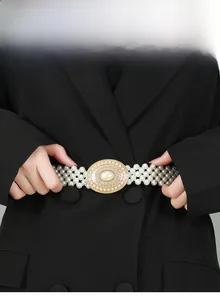 Detail van elegante parelketting riem met strass gesp gedragen op een zwarte blazer jas
