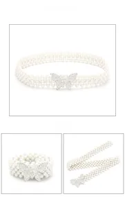 Detail van zilveren vlindergesp met strass op een drierijige witte parelmoeren tailleriem