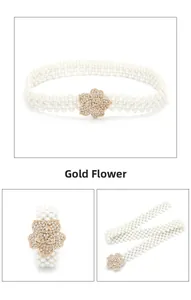 Detail van witte parelriem voor dames met een decoratieve gouden bloemgesp met kristallen