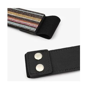 Close-up detail of black elastic waist belt with colorful rhinestones and metal snap buttons.