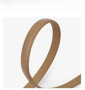 Détail de la ceinture en cuir marron montrant des coutures de qualité et une texture lisse