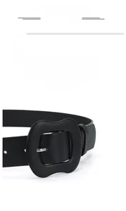 Detail of black leather belt with a matching covered rectangular buckle and litchi texture