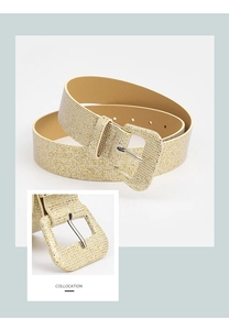 Detailed view of the sparkling gold glitter texture and matching square buckle on a PU belt