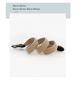 Détail de la ceinture tressée élastique beige avec boucle en métal gris foncé et cuir