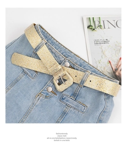 Detail of glitter gold waist belt with square buckle on denim skirt and magazine