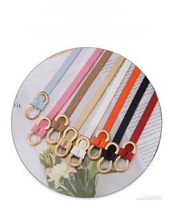 Close-up of colorful slim fashion belts featuring elegant golden 8-shaped metal buckles