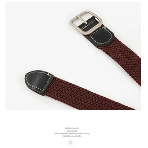Detail view of woven stretch belt with matte silver buckle and white stitching accents