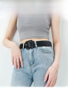 Schwarzer Ledergürtel mit quadratischer Schnalle auf hellblauer Denim-Jeans im Detail