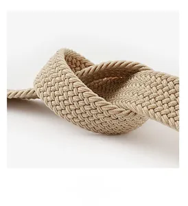Vue macro d'une ceinture tressée kaki montrant la texture élastique et les détails du nœud