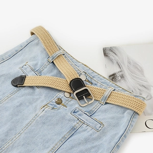 Braided elastic khaki belt with silver square buckle on blue jeans for casual wear