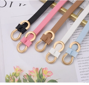 Detail of five slim women's belts in soft colors with elegant golden infinity buckles