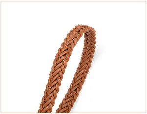 Close-up of brown woven leather belt detail showing intricate braided texture and craftsmanship