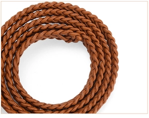 Close-up of brown woven belt with detailed spiral texture and vintage bronze buckle