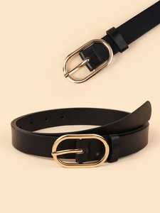 Detail view of oval golden alloy buckle on slim black leather belt for jeans