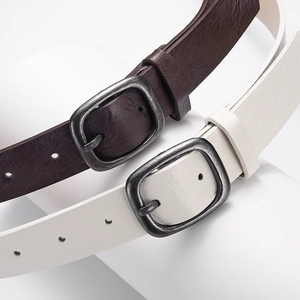Minimalist leather belts in dark brown and off-white with vintage silver buckle hardware