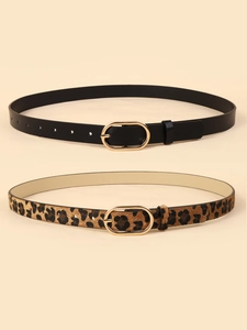 Close-up of leopard print and black leather belts with gold metal oval buckles