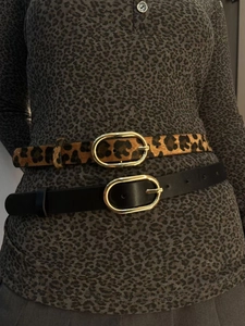 Detail view of leopard print faux horsehair belt and black leather belt with gold buckles