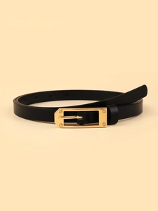 Close-up of thin black leather belt featuring a vintage gold rectangular buckle with rivets