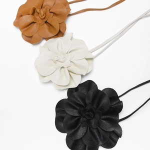 Trois colliers à fleurs en cuir marron, blanc et noir avec de fines cordons minimalistes