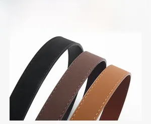 Detail of three faux leather belts in black and brown with fine stitching texture