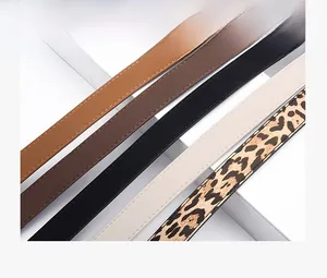Close-up of minimalist skinny belts in brown, black and leopard print with fine stitching