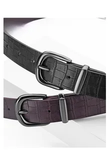 Detail of crocodile embossed faux leather belts with polished gunmetal pin buckles