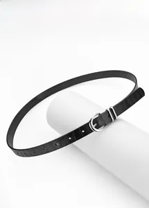 Detail of slim black belt with crocodile texture and silver D-ring buckle on a white stand