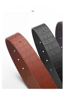 Detailed macro view showing crocodile embossed texture on faux leather belts in brown and black