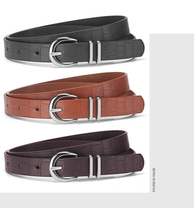 Detailed view of crocodile pattern leather belts in black, brown and tan with silver buckles
