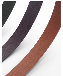 Detailed texture view of faux crocodile skin belts in green, purple, and brown colors