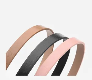 Detailed close-up of genuine leather belts showing lychee texture in black, brown and pink