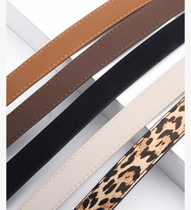 Close-up of five colorful slim faux leather belts with stitching details in diagonal layout