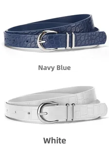 Detailed view of navy blue and white crocodile pattern belts with silver buckle