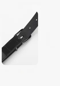 Detail of black pebbled leather belt with reinforced stitching and silver metallic buckle