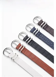 Detail of colorful crocodile embossed leather belts with polished zinc alloy buckles