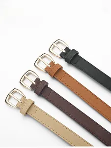 Détail de quatre ceintures fines en similicuir noir, marron et beige avec boucles dorées