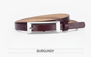 Close-up of a burgundy slim leather belt with a rectangular silver metal buckle on white