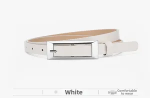 Detail shot of a slim white leather belt featuring a polished silver rectangular buckle