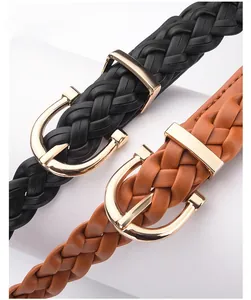 Close-up of woven leather belts in black and brown with golden alloy pin buckles