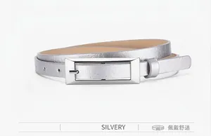 Detail of silver rectangle buckle and sleek textured leather strap on women thin belt